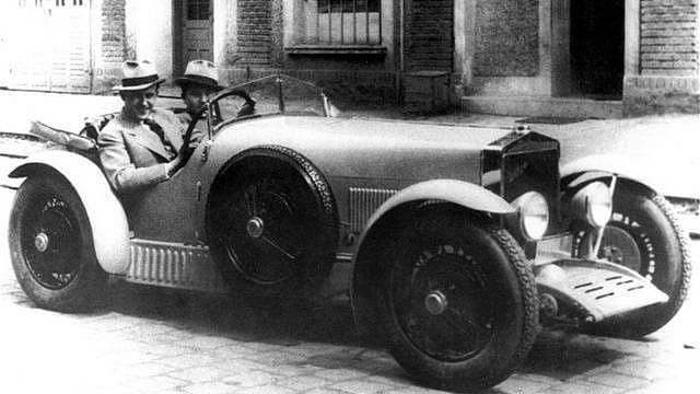 Voskovec a Werich, známí humoristé—umělci z Prahy při zájezdu do Prostějova, kde sehráli 16. a 17. května 1930 s velikým úspěchem revue „Ostrov Dynamit“ a „Fata morgana“, navštívili tamní automobilku Wikov.